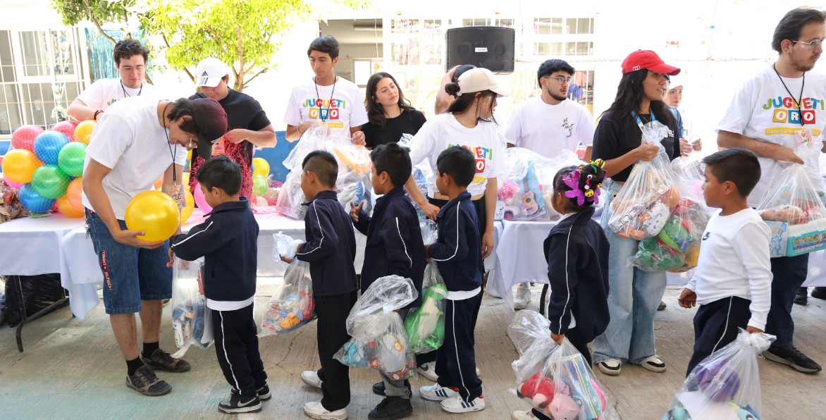Niños recibiendo juguetes en evento escolar