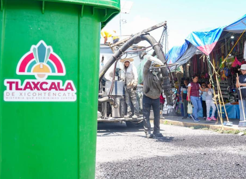 Trabajadores realizan labores de bacheo en una calle de Tlaxcala.