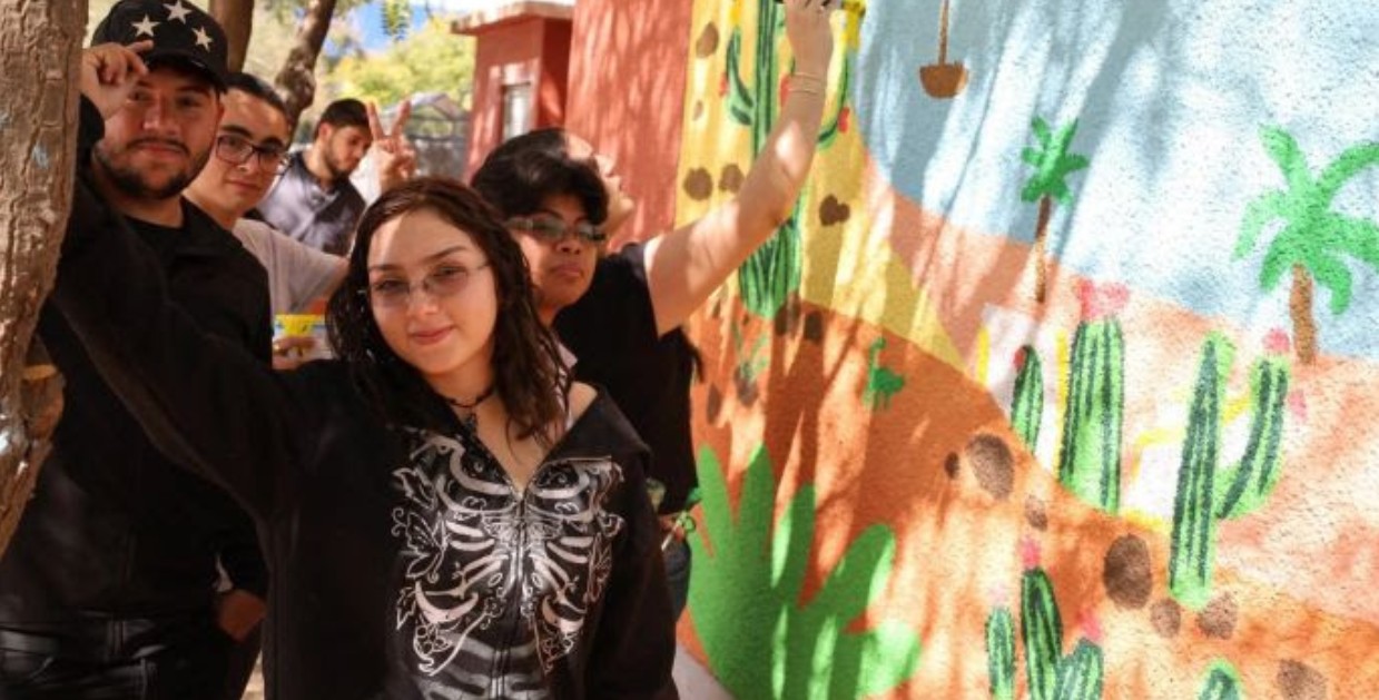 Jóvenes pintando murales comunitarios en espacios públicos de México.
