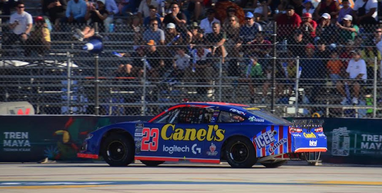 Max Gutiérrez junto a su auto NASCAR en Puebla