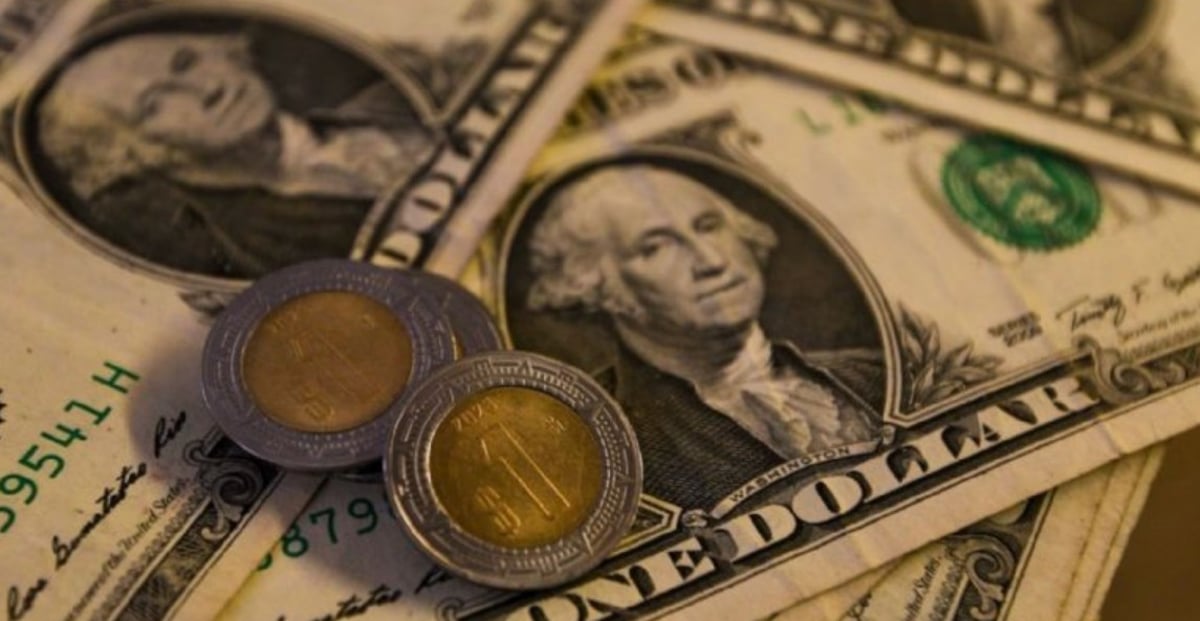 Billetes de dólares y pesos mexicanos junto a pantalla con tipo de cambio