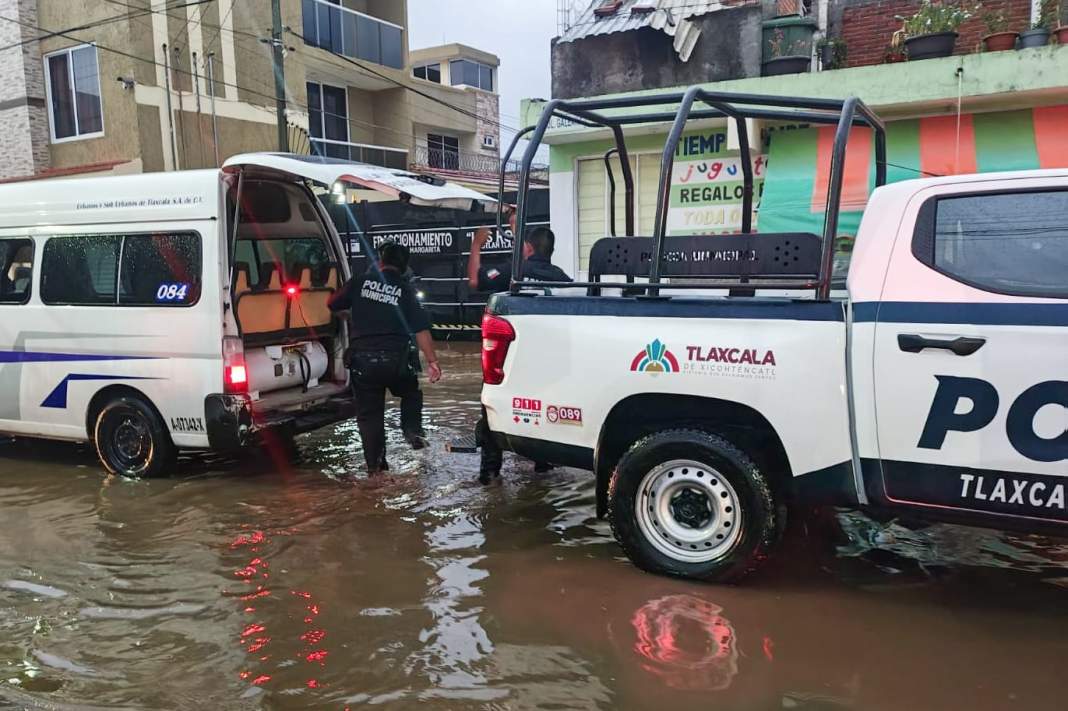 Policías rescatan a familia atrapada por inundación en Tlaxcala.
