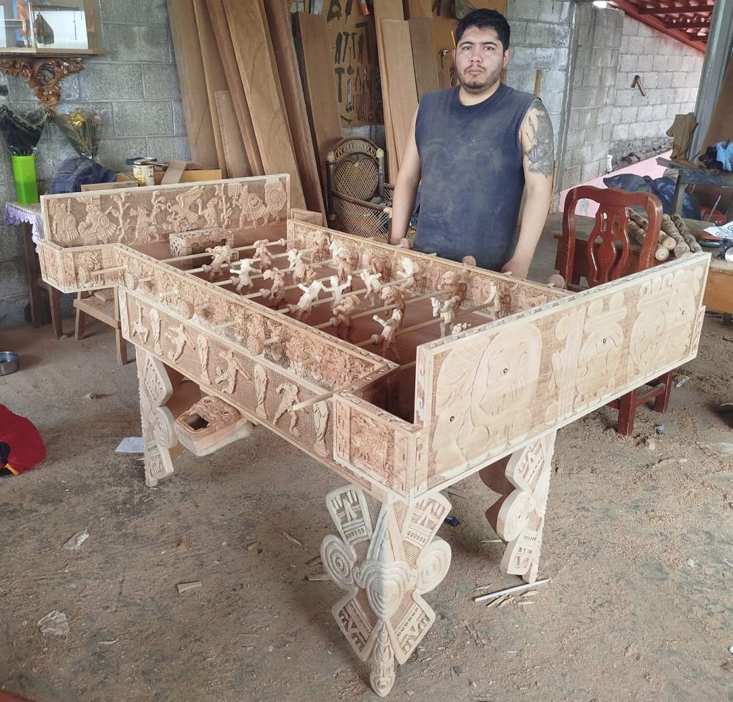 Artesano de Tlaxcala con su obra de madera inspirada en dioses y fútbol