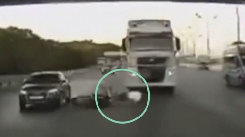 Hombre derrapa con su moto a alta velocidad, casi es atropellado por un tráiler (Vídeo)