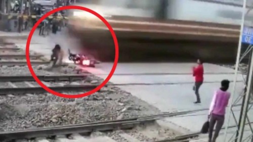 Motociclista casi muere triturado por un tren, una distracción en un instante causó el incidente (Vídeo)