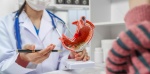 Persona con dolor abdominal consultando a un médico