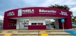 Estudiantes caminando bajo la lluvia en Puebla.