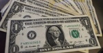 Billetes de dólares y pesos mexicanos junto a tipo de cambio